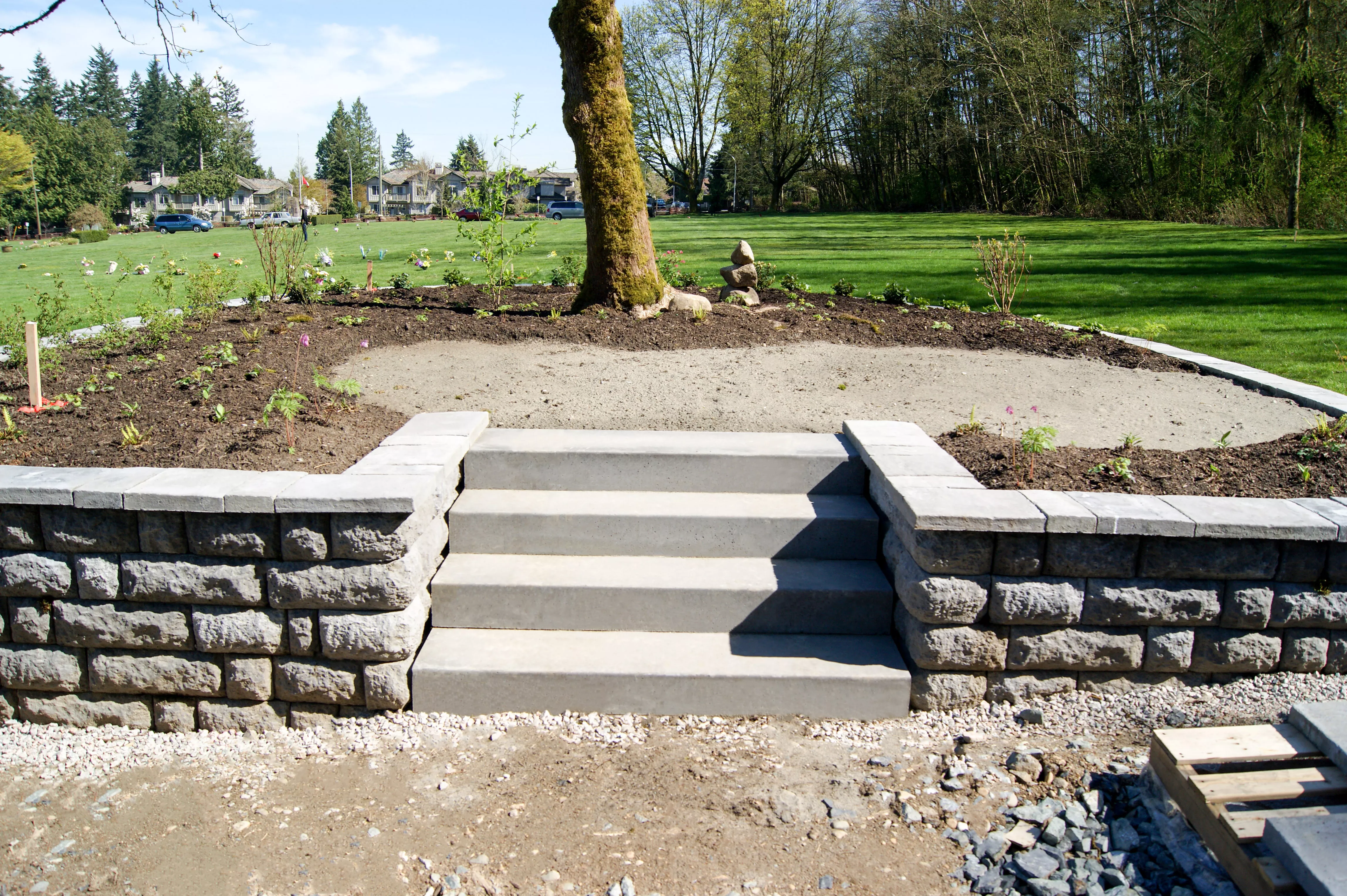 Precast concrete landscape stairs positioned within an opening between retaining-wall sections