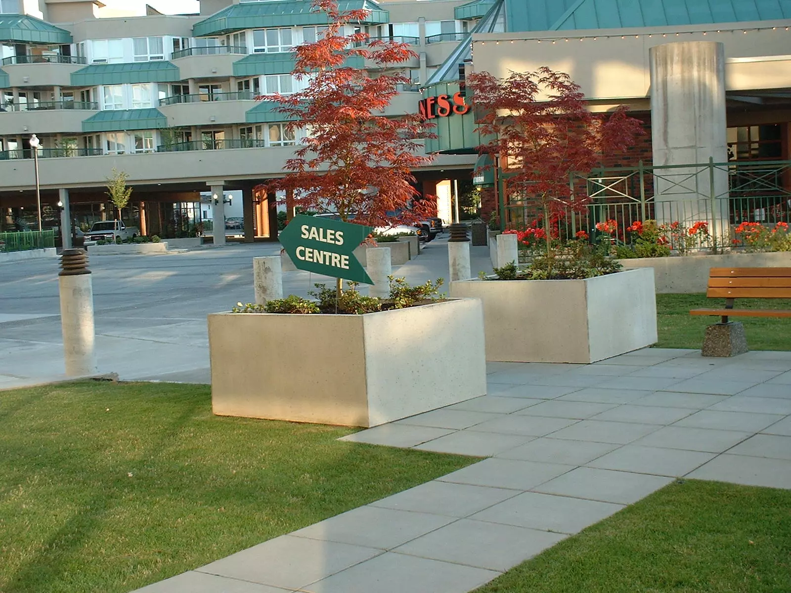 Large square precast concrete planters in a commercial plaza