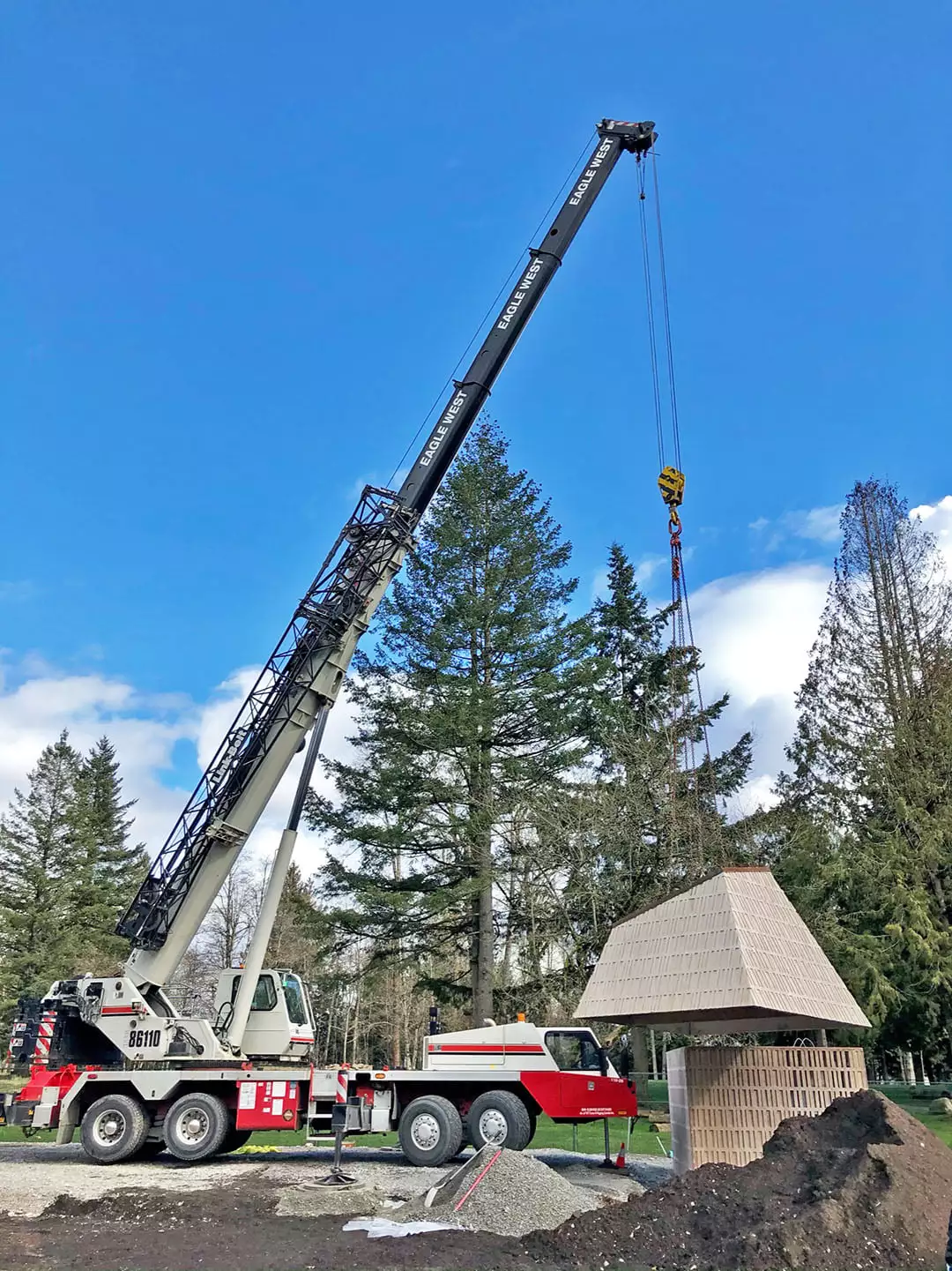 Crane completing placement of a precast concrete park washroom
