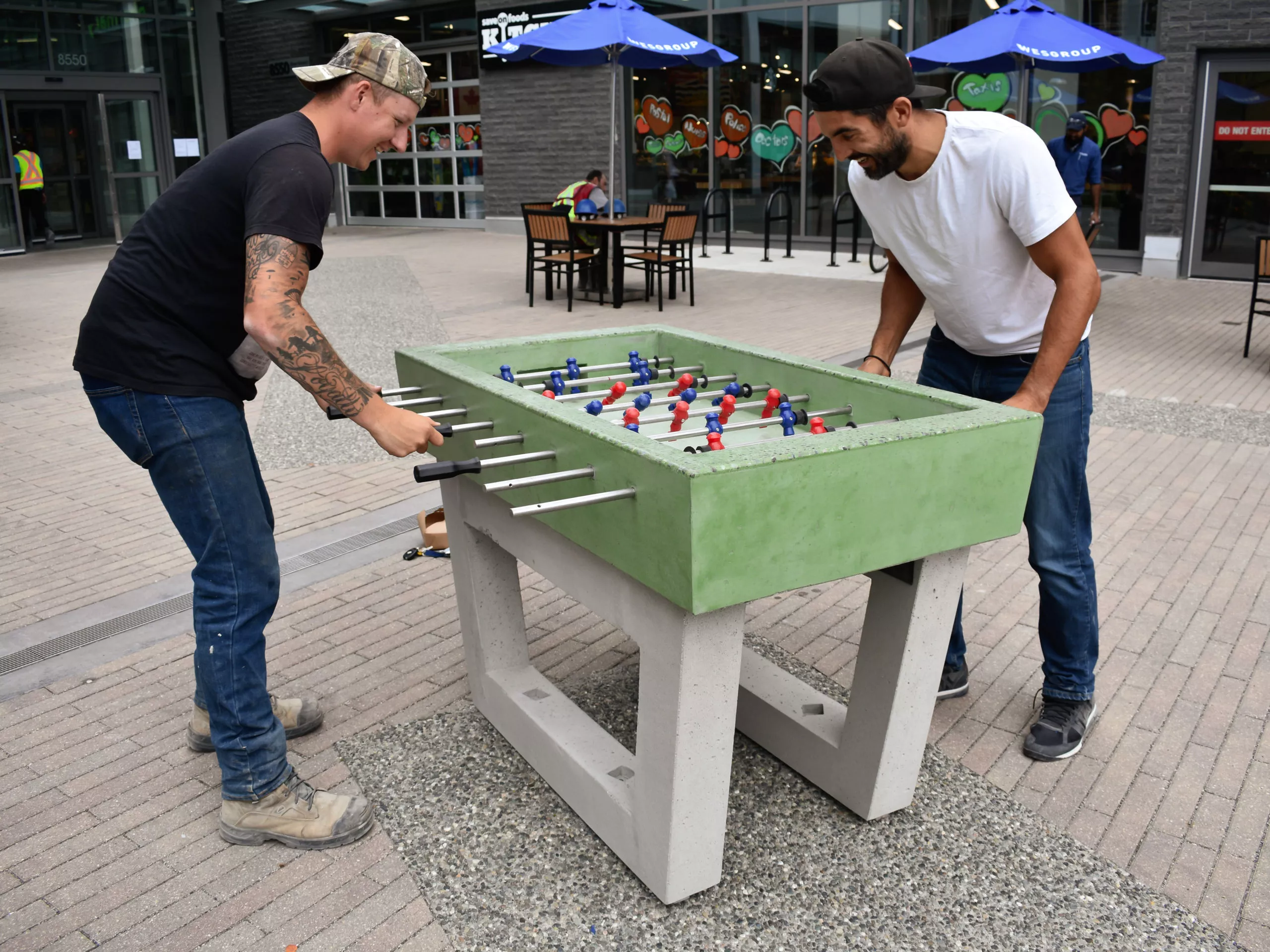 People playing on a precast concrete outdoor foosball table