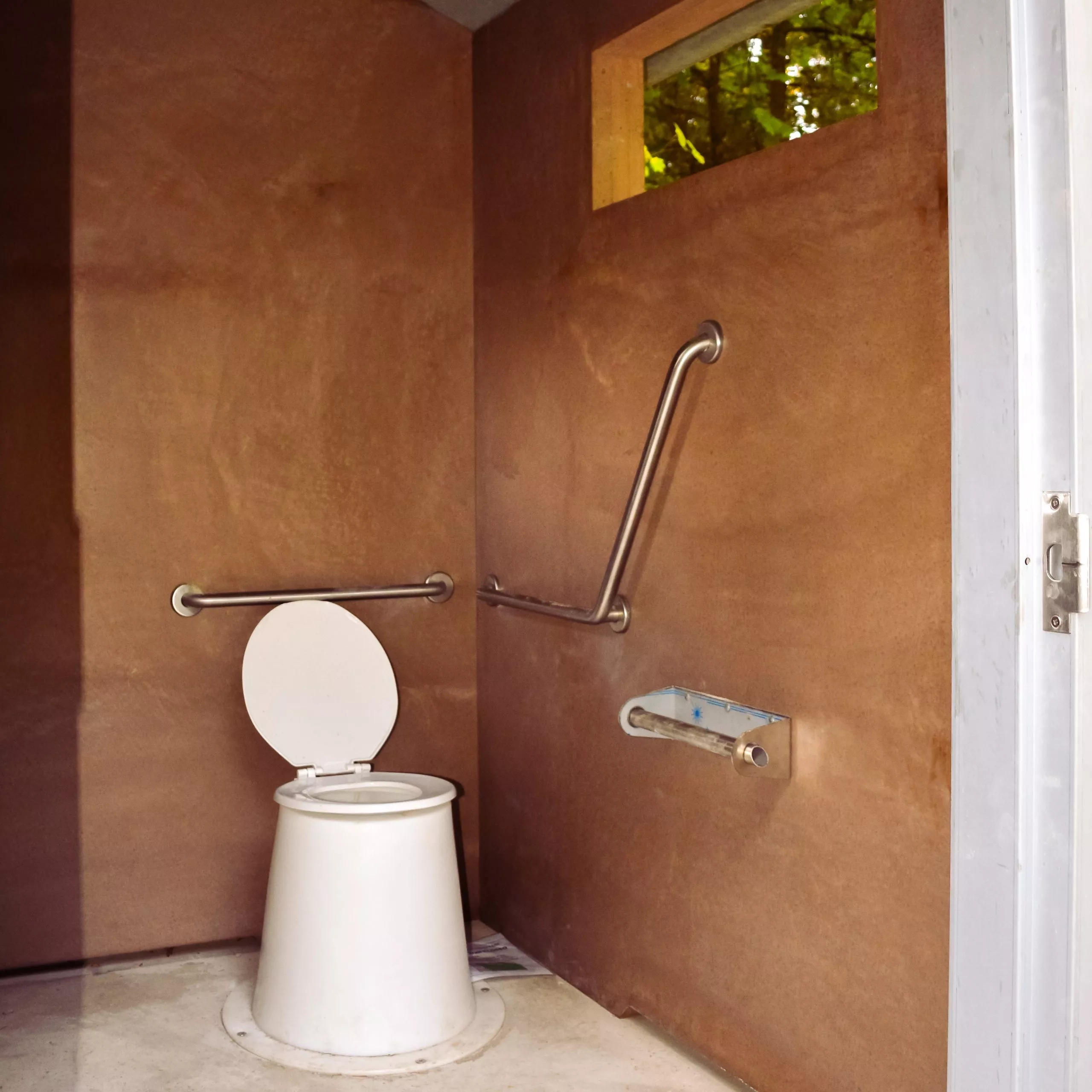 Accessible outhouse toilet inside a precast concrete outhouse