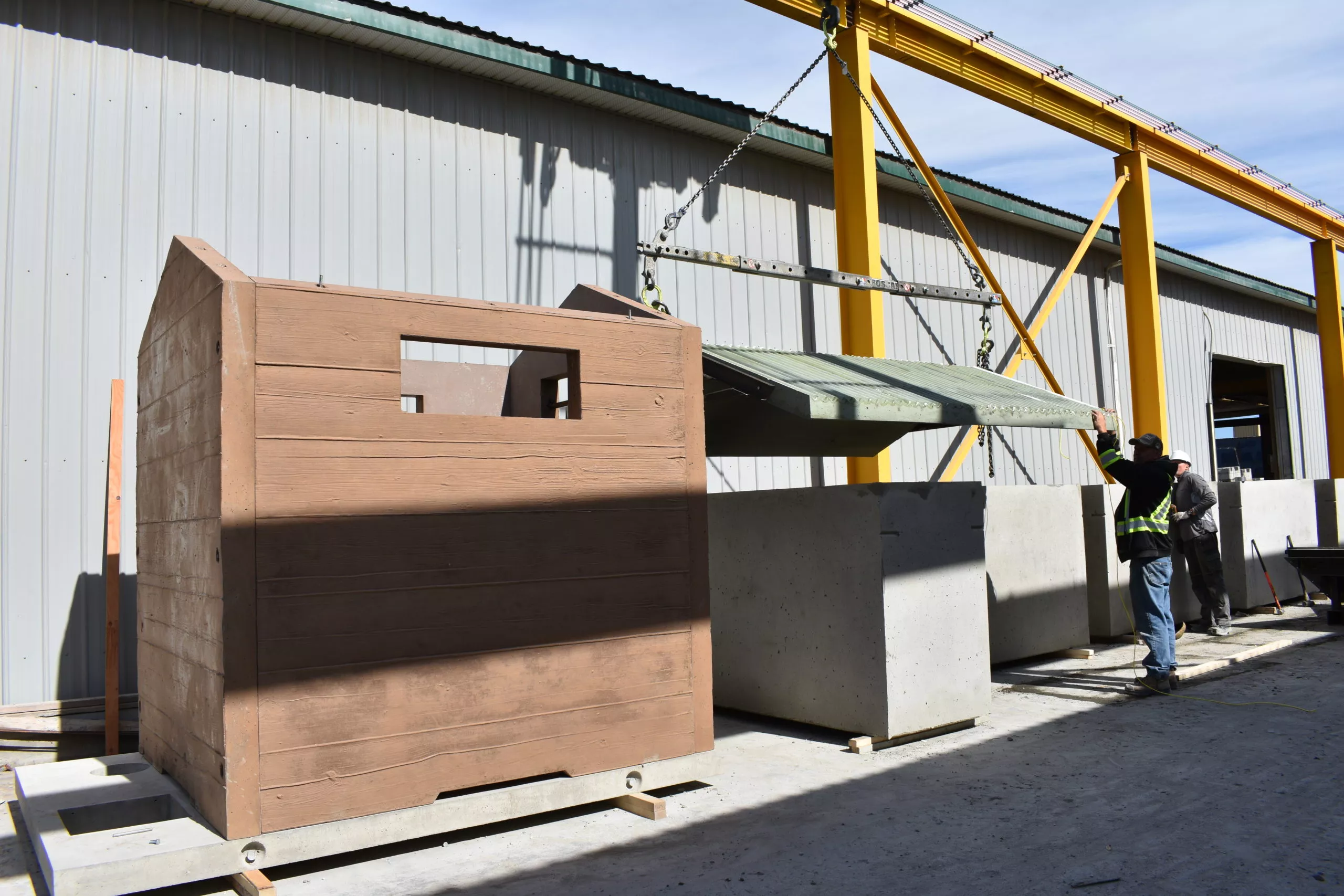 Precast concrete pit toilet being unloaded for outdoor site installation