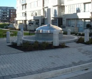 Urban plaza structure with stainless steel and Langley concrete base in residential development