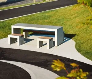concrete picnic table installed in a modern public park with matching seating and landscaping