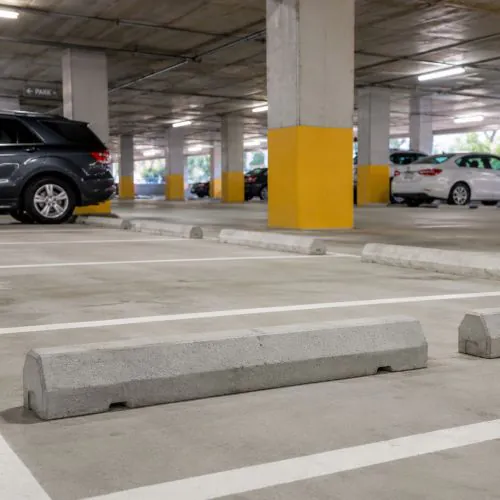 Concrete parking garage wheel stops installed in a multi-level parkade